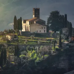Borgo medievale in collina, con chiesa e torre, ideale per un giro in moto nella Garfagnana.