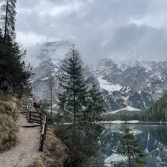 Sentiero da Brunico a Lago di Braies, con montagne innevate e riflessi sull'acqua.