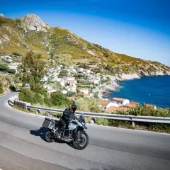 Motociclista esplora la costa dell'Isola d'Elba, tra villaggi pittoreschi e mare blu. Un'ottima idea per scoprire cosa vedere!