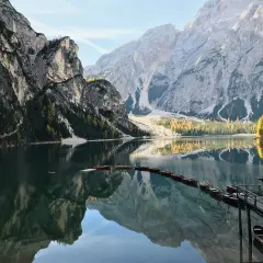 Un suggestivo itinerario al Lago di Braies e dintorni, con barche di legno ormeggiate e montagne maestose riflesse nell'acqua cristallina.