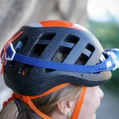 Casco da arrampicata nero con dettagli arancioni e lampada frontale. Per capire se un casco è omologato, controlla le etichette interne.