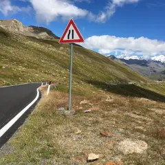Strada di montagna con segnale di restringimento. Perfetto per sapere dove andare in moto, tra panorami mozzafiato e curve emozionanti.