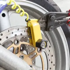 Pinza taglia bulloni su lucchetto giallo per disco freno moto. Un tentativo di furto sventato, dimostrando l'efficacia del miglior antifurto meccanico moto.