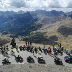 Un gruppo di motociclisti si gode un panorama mozzafiato sulle montagne del Piemonte.