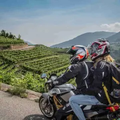 Coppia in moto esplora il Cilento tra vigneti terrazzati e montagne verdi. Un'avventura panoramica.