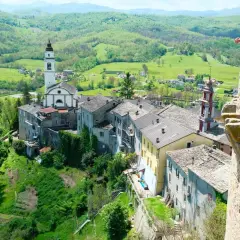 Borgo pittoresco sull'Appennino Romagnolo, con chiesa e campanile che dominano il paesaggio verdeggiante. Un luogo incantevole da scoprire.