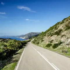 Strada panoramica lungo la costa sarda, un viaggio da Cagliari ad Alghero tra mare blu e macchia mediterranea.