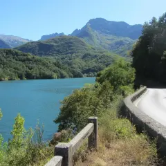 Strada panoramica sul lago, con montagne verdi sullo sfondo. Un viaggio verso il passo dei Carpinelli.