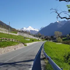 Strada panoramica verso Champoluc con montagne innevate sullo sfondo.