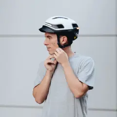 Uomo con casco bianco e nero, con luci LED integrate. Le misure del casco moto sono importanti per la sicurezza.