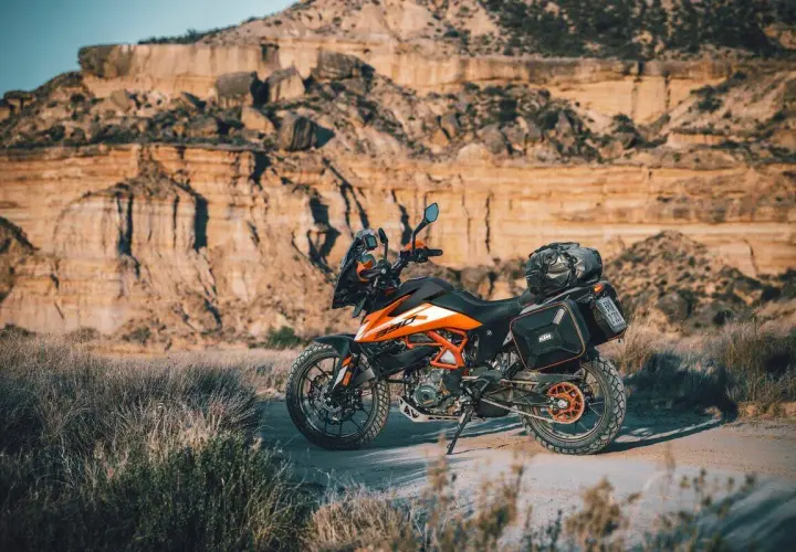 Una moto da avventura pronta per esplorare sentieri in montagna. Il paesaggio arido e roccioso fa da sfondo perfetto per questa avventura.
