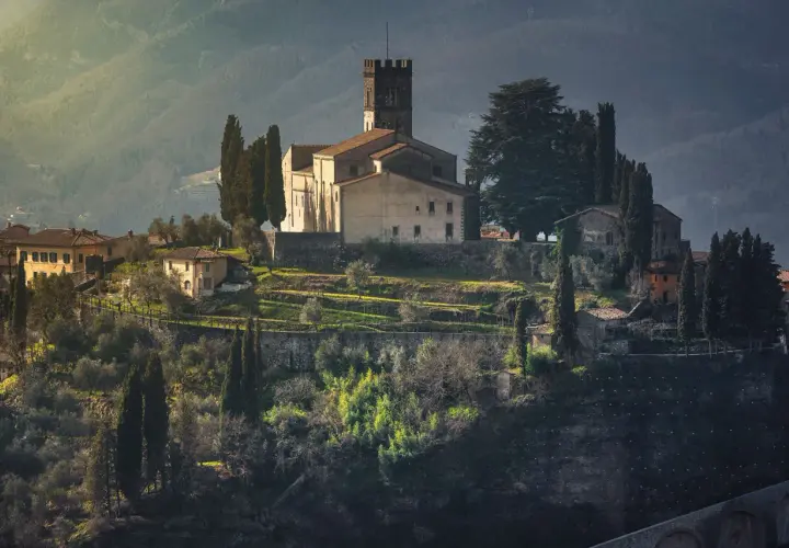 Borgo medievale in collina, con chiesa e torre, ideale per un giro in moto nella Garfagnana.