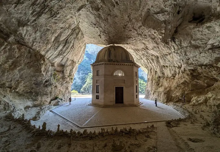 Il tempio del Valadier, un gioiello architettonico incastonato in una grotta naturale, con la sua cupola che si staglia contro il verde della valle.