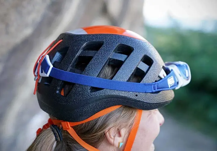 Casco da arrampicata nero con dettagli arancioni e lampada frontale. Per capire se un casco è omologato, controlla le etichette interne.
