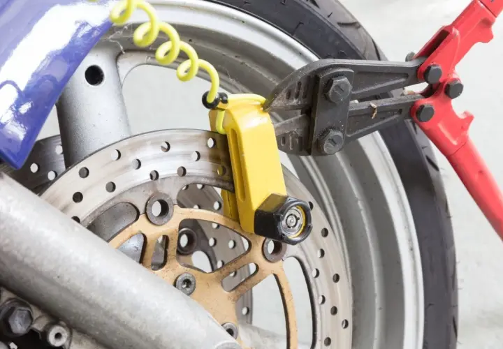 Pinza taglia bulloni su lucchetto giallo per disco freno moto. Un tentativo di furto sventato, dimostrando l'efficacia del miglior antifurto meccanico moto.