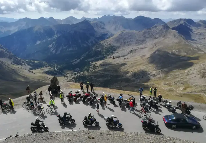 Un gruppo di motociclisti si gode un panorama mozzafiato sulle montagne del Piemonte.