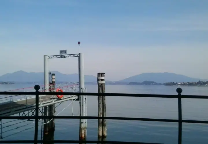 Molo di Meina, ideale per una pausa durante il giro del Lago Maggiore in moto. Montagne sullo sfondo.