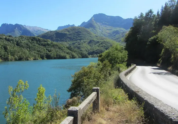 Strada panoramica sul lago, con montagne verdi sullo sfondo. Un viaggio verso il passo dei Carpinelli.