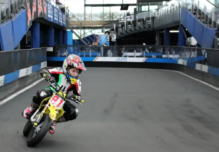 Giovane pilota in azione sul circuito del Lario, con la sua moto da corsa gialla e il numero 91 ben visibile.