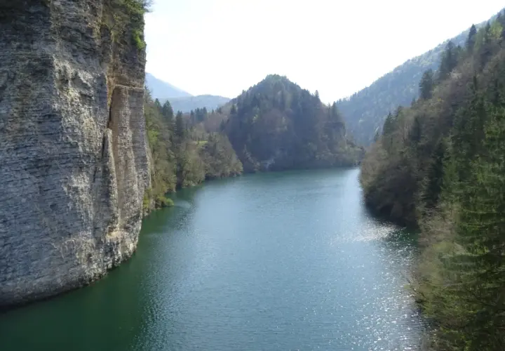Scorci mozzafiato del lago di Senaiga, con imponenti pareti rocciose e fitte foreste che abbracciano le sue acque cristalline.