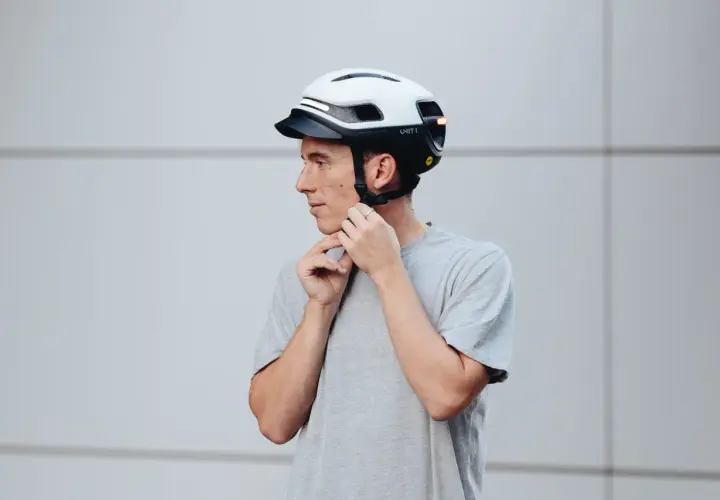 Uomo con casco bianco e nero, con luci LED integrate. Le misure del casco moto sono importanti per la sicurezza.