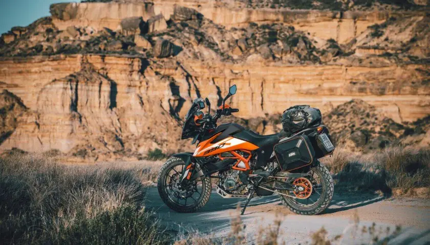 Una moto da avventura pronta per esplorare sentieri in montagna. Il paesaggio arido e roccioso fa da sfondo perfetto per questa avventura.