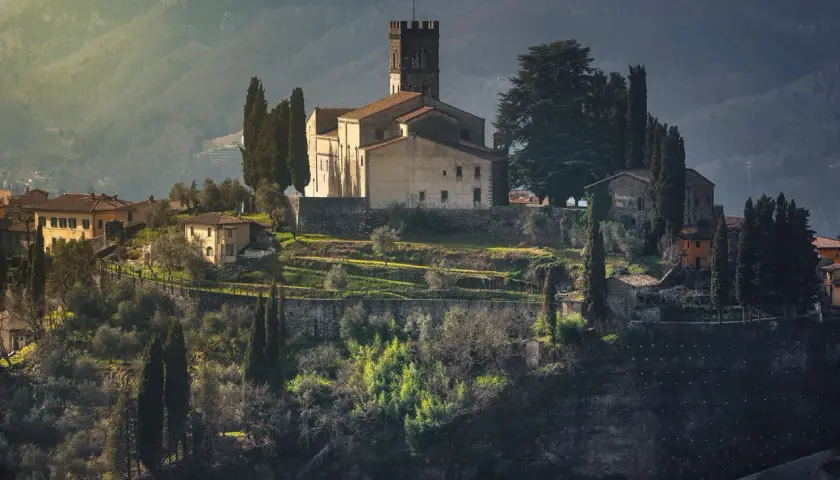 Borgo medievale in collina, con chiesa e torre, ideale per un giro in moto nella Garfagnana.