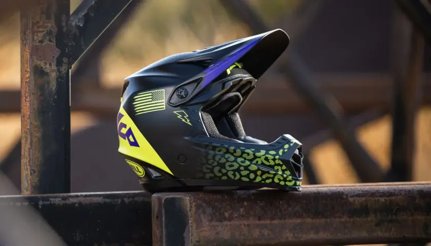 Casco da moto per bambini, nero con dettagli leopardati verdi e bandiera americana gialla. Disponibile in varie taglie.