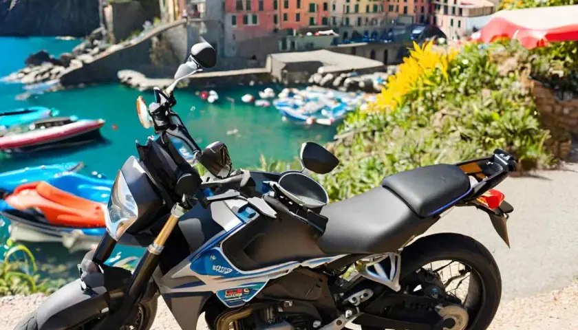Moto parcheggiata con vista sul mare e case colorate della Liguria. Un'avventura su due ruote tra i passi liguri.
