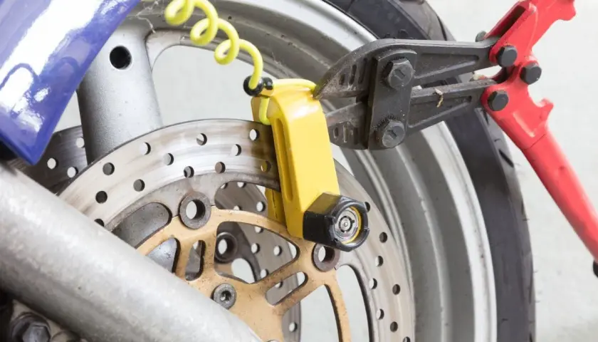 Pinza taglia bulloni su lucchetto giallo per disco freno moto. Un tentativo di furto sventato, dimostrando l'efficacia del miglior antifurto meccanico moto.
