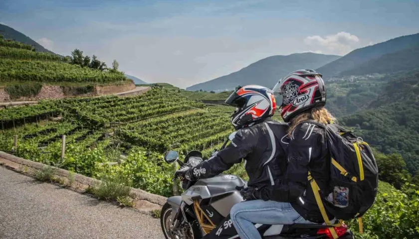 Coppia in moto esplora il Cilento tra vigneti terrazzati e montagne verdi. Un'avventura panoramica.