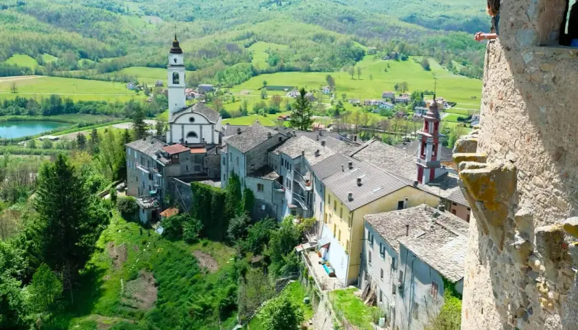 Borgo pittoresco sull'Appennino Romagnolo, con chiesa e campanile che dominano il paesaggio verdeggiante. Un luogo incantevole da scoprire.