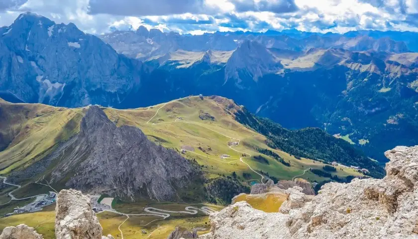Panorami mozzafiato per itinerari moto 2 giorni. Strade tortuose tra le vette delle Dolomiti, con pascoli verdi e cime imponenti.