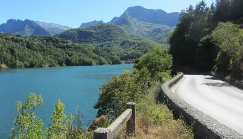 Strada panoramica sul lago, con montagne verdi sullo sfondo. Un viaggio verso il passo dei Carpinelli.