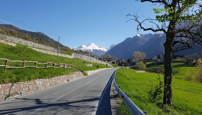 Strada panoramica verso Champoluc con montagne innevate sullo sfondo.