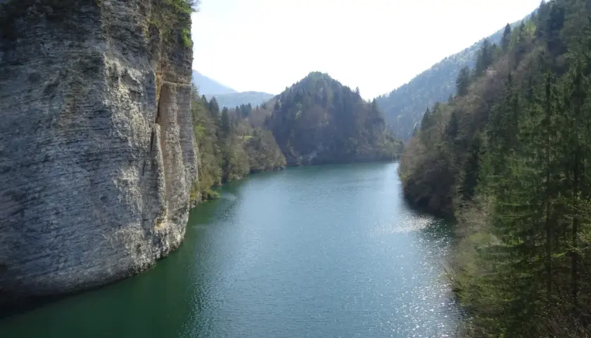 Scorci mozzafiato del lago di Senaiga, con imponenti pareti rocciose e fitte foreste che abbracciano le sue acque cristalline.