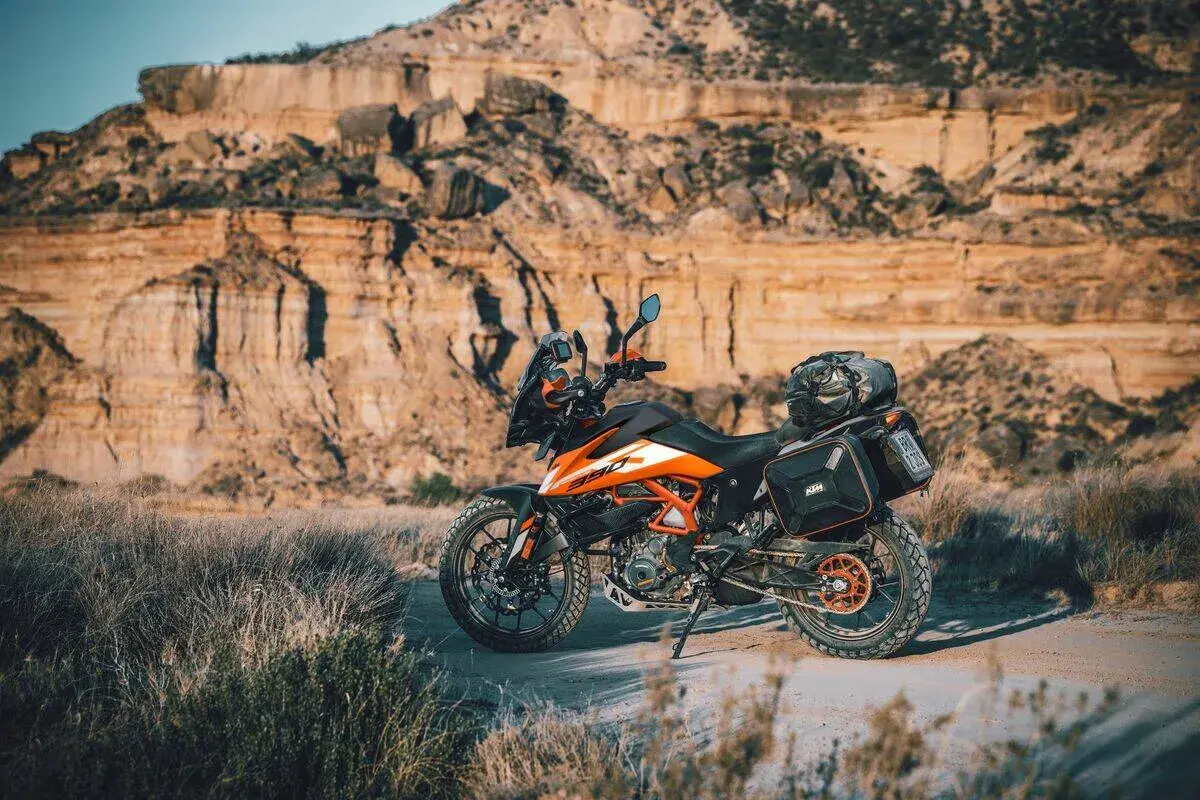 Una moto da avventura pronta per esplorare sentieri in montagna. Il paesaggio arido e roccioso fa da sfondo perfetto per questa avventura.