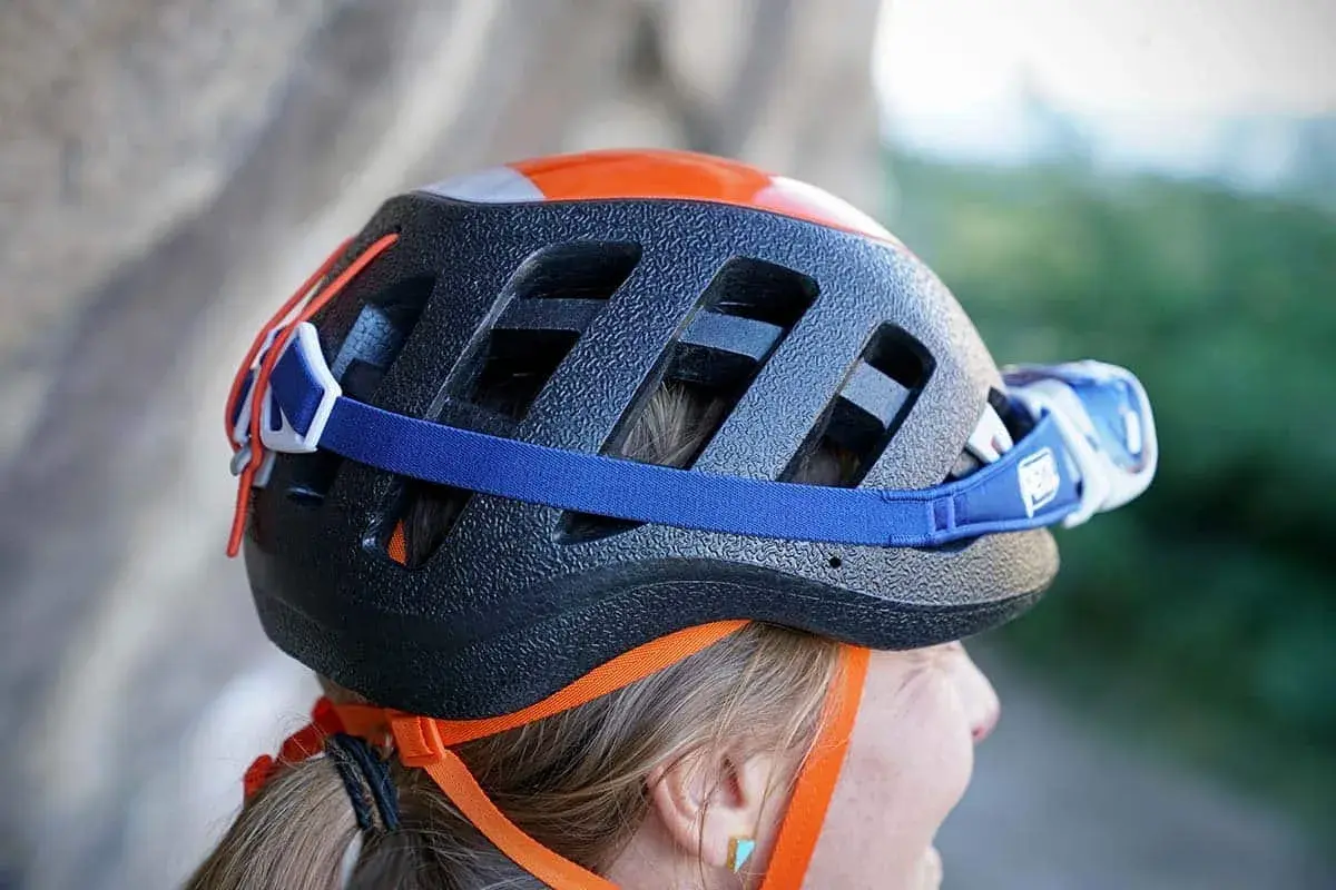 Casco da arrampicata nero con dettagli arancioni e lampada frontale. Per capire se un casco è omologato, controlla le etichette interne.
