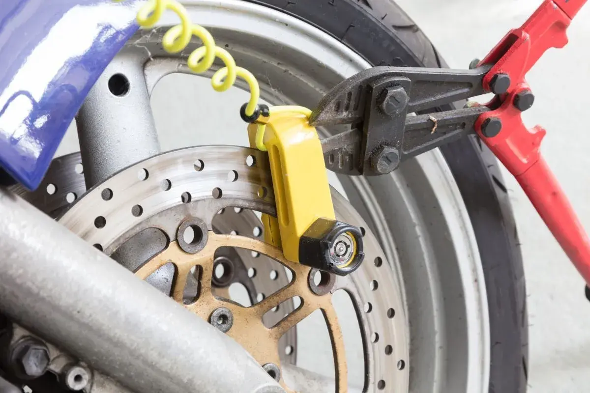 Pinza taglia bulloni su lucchetto giallo per disco freno moto. Un tentativo di furto sventato, dimostrando l'efficacia del miglior antifurto meccanico moto.