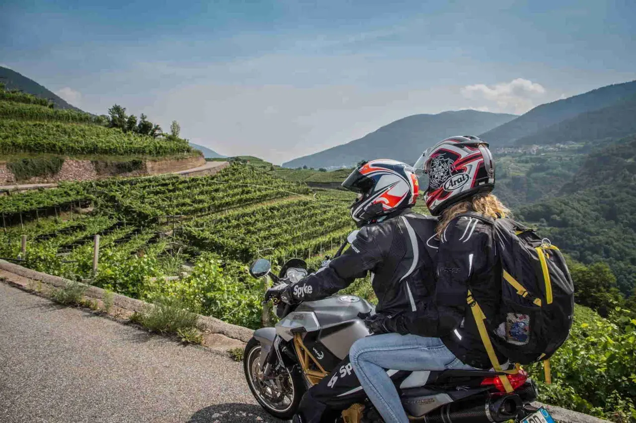 Coppia in moto esplora il Cilento tra vigneti terrazzati e montagne verdi. Un'avventura panoramica.