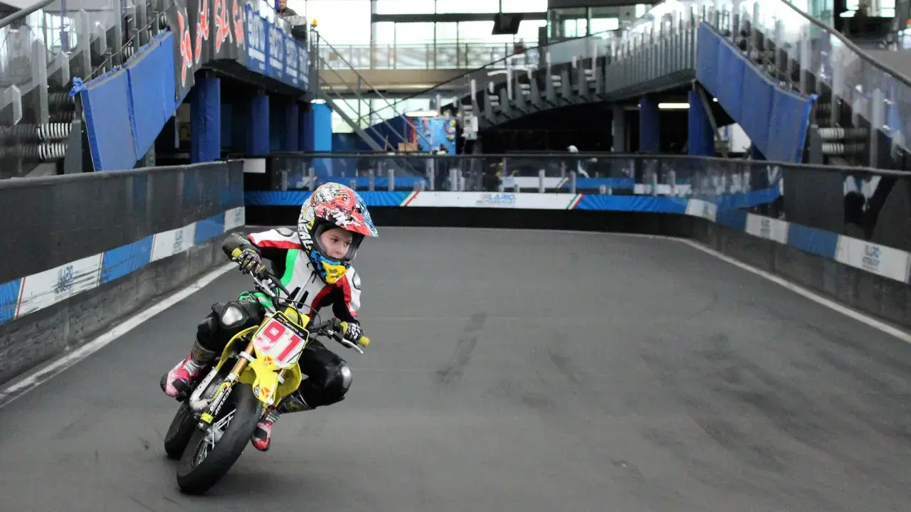 Giovane pilota in azione sul circuito del Lario, con la sua moto da corsa gialla e il numero 91 ben visibile.