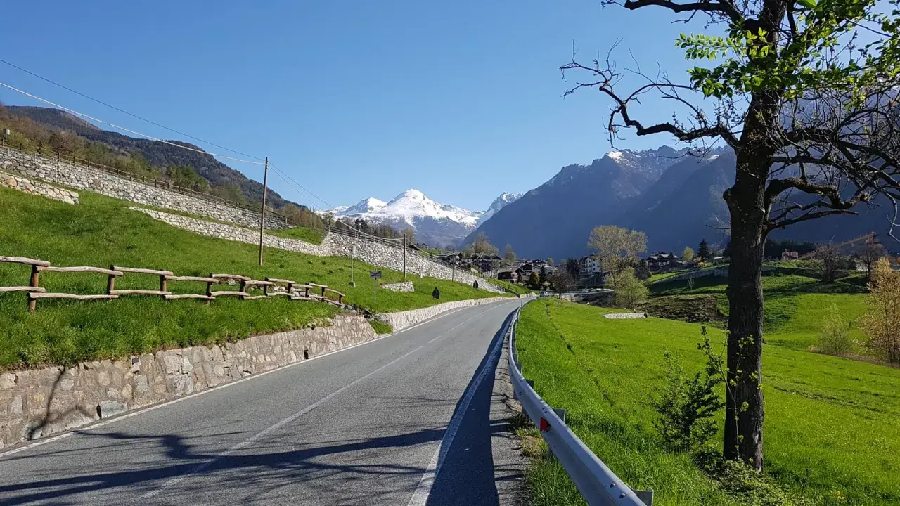 Strada panoramica verso Champoluc con montagne innevate sullo sfondo.