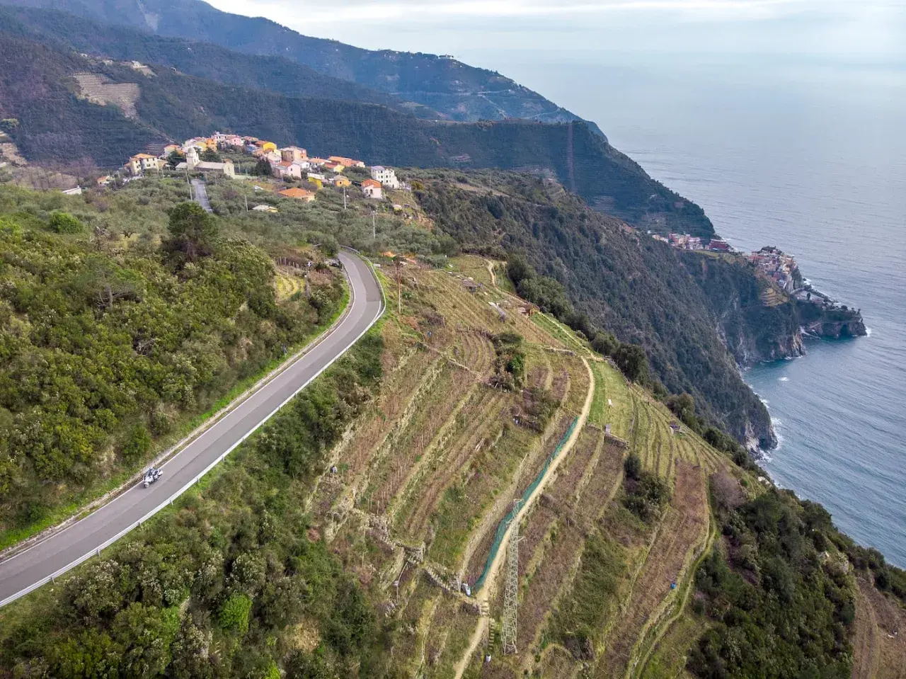 Un viaggio in moto tra i terrazzamenti e i borghi delle 5 Terre, con il mare blu a fare da cornice.