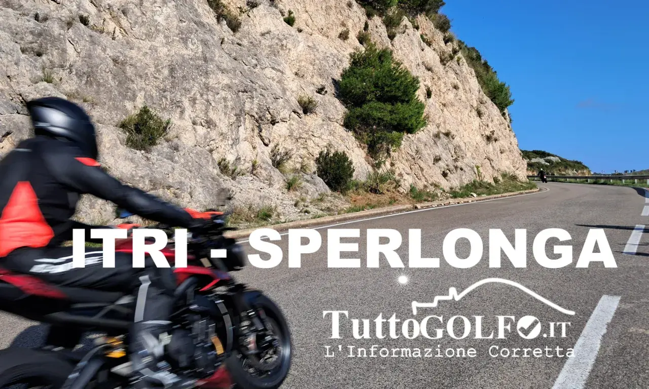 Motociclista in corsa su una strada panoramica tra Itri e Sperlonga, con rocce scoscese e cielo azzurro.