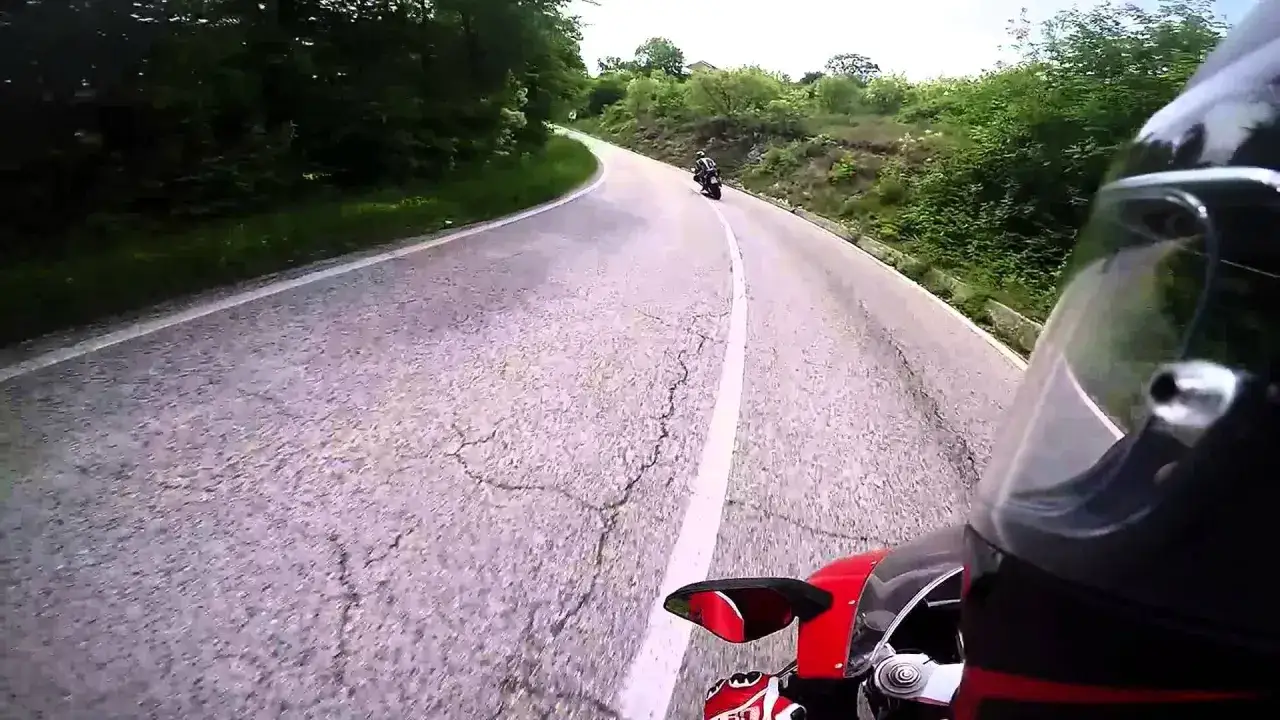 In sella alla moto, percorrendo il passo Castrin tra curve e verde.