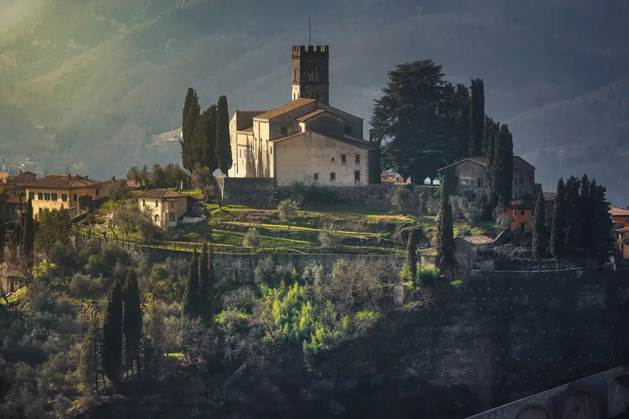 Borgo medievale in collina, con chiesa e torre, ideale per un giro in moto in Garfagnana.
