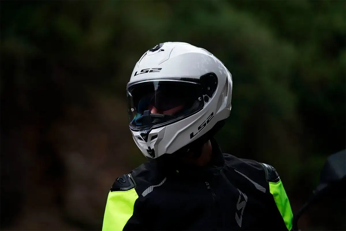 Un motociclista indossa un casco integrale bianco LS2, pronto per un'avventura su strada.