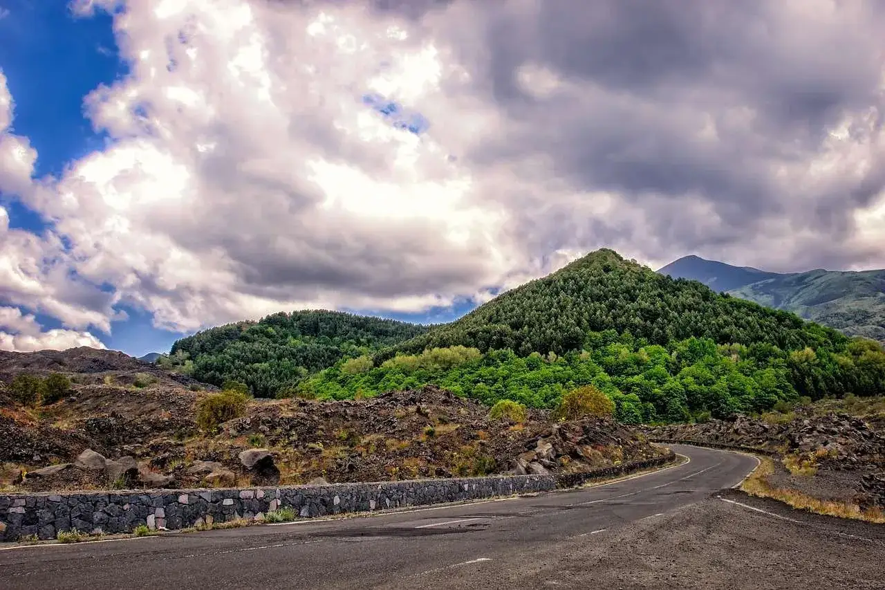Strada tortuosa tra rocce laviche e boschi lussureggianti, perfetta per un'avventura in Sicilia in moto 10 giorni.