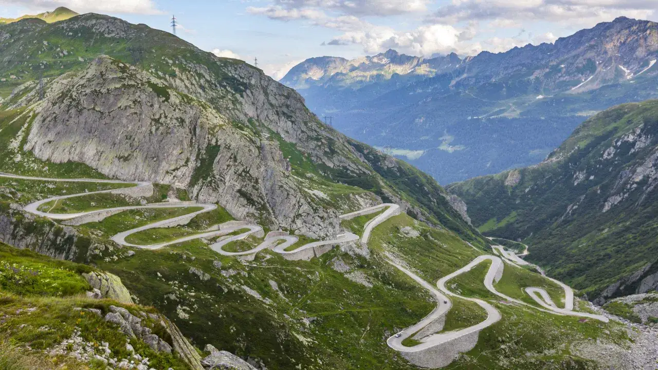 Strada tortuosa tra montagne verdi, un paesaggio alpino mozzafiato che ricorda la bellezza di Merano, Trentino.