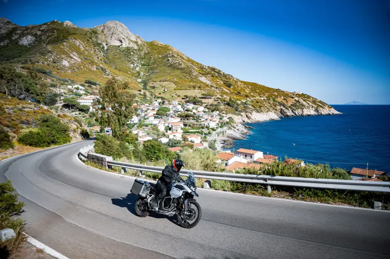 Motociclista esplora la costa dell'Isola d'Elba, tra villaggi pittoreschi e mare blu. Un'ottima idea per scoprire cosa vedere!